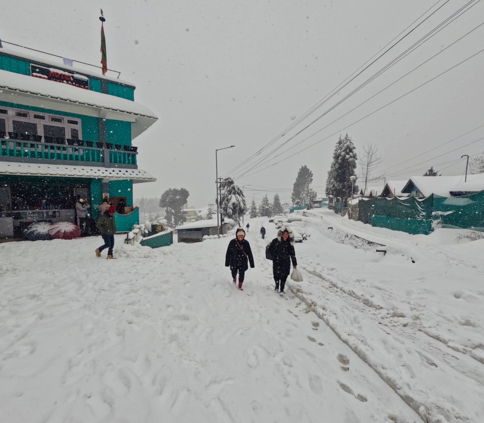 Wild Hill Adventure Snow-covered streets and hotel buildings in Tawang during winter, showcasing the Himalayan winter experience offered by the Tawang winter senior citizen tour package.
